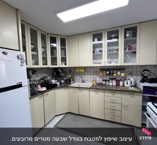 מטבח עם ארונות וכלי מטבח שונים